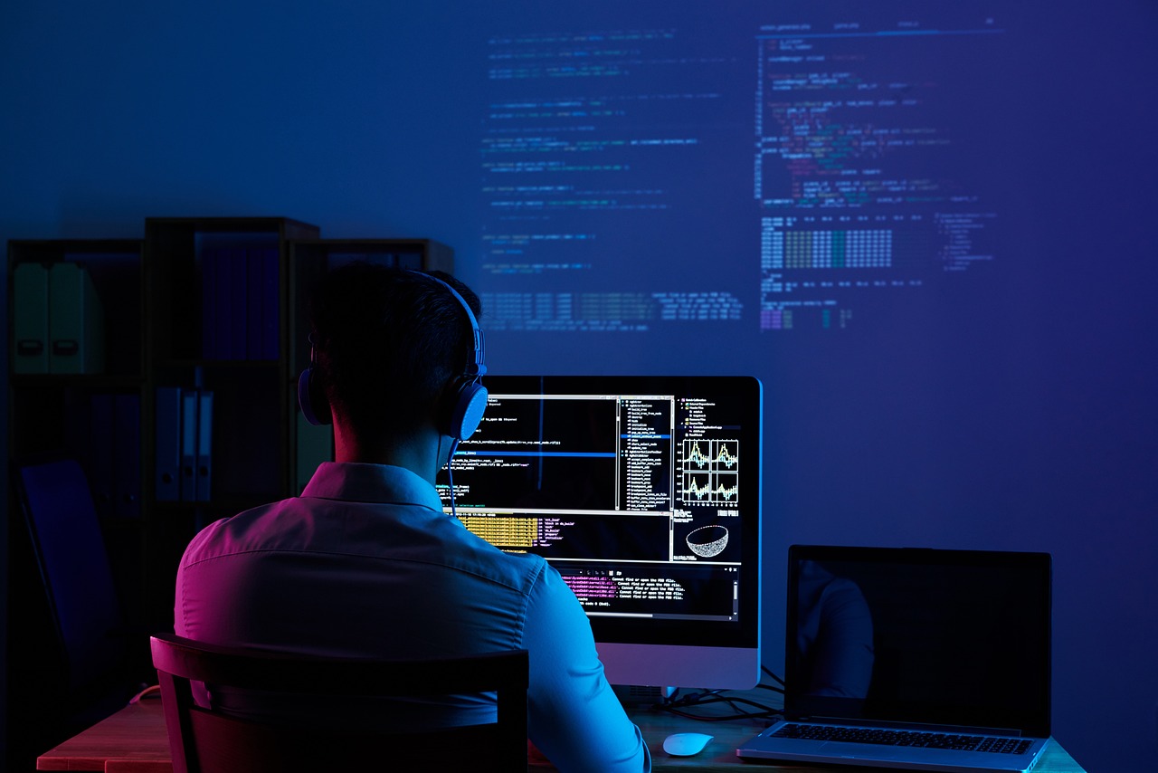A software developer working in a dimly lit environment, analyzing complex code on multiple screens with automation tools and data analytics.